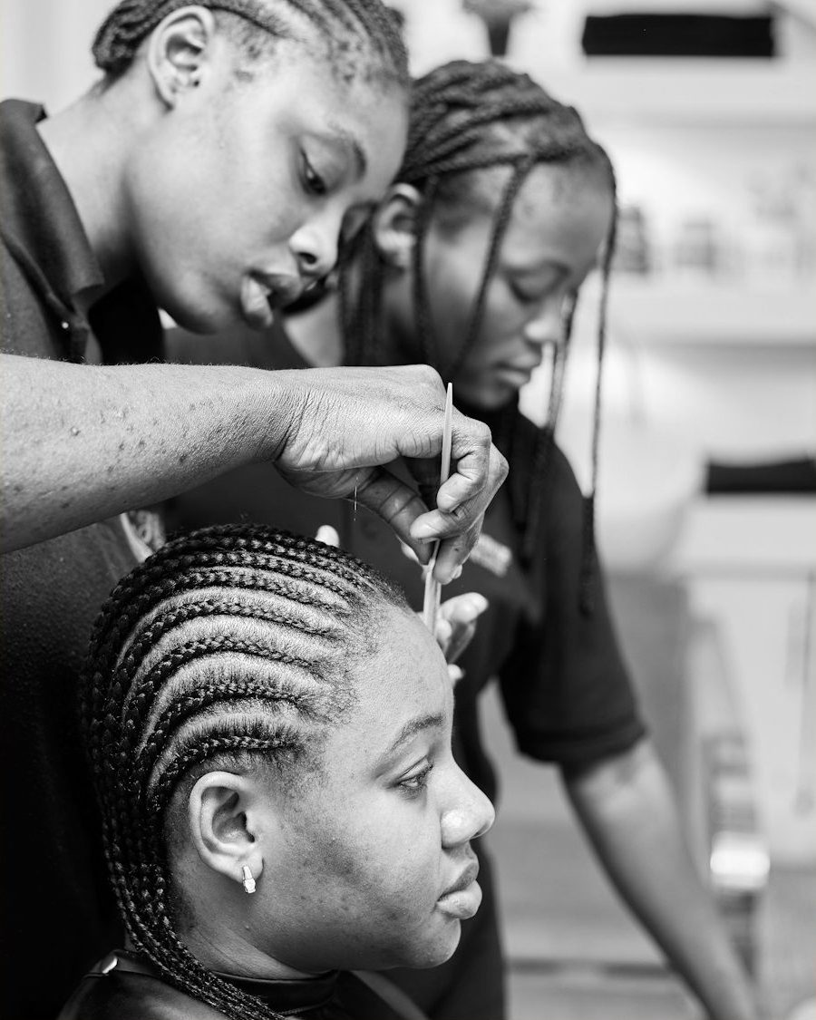 Stylist braiding a client's hair in the studio